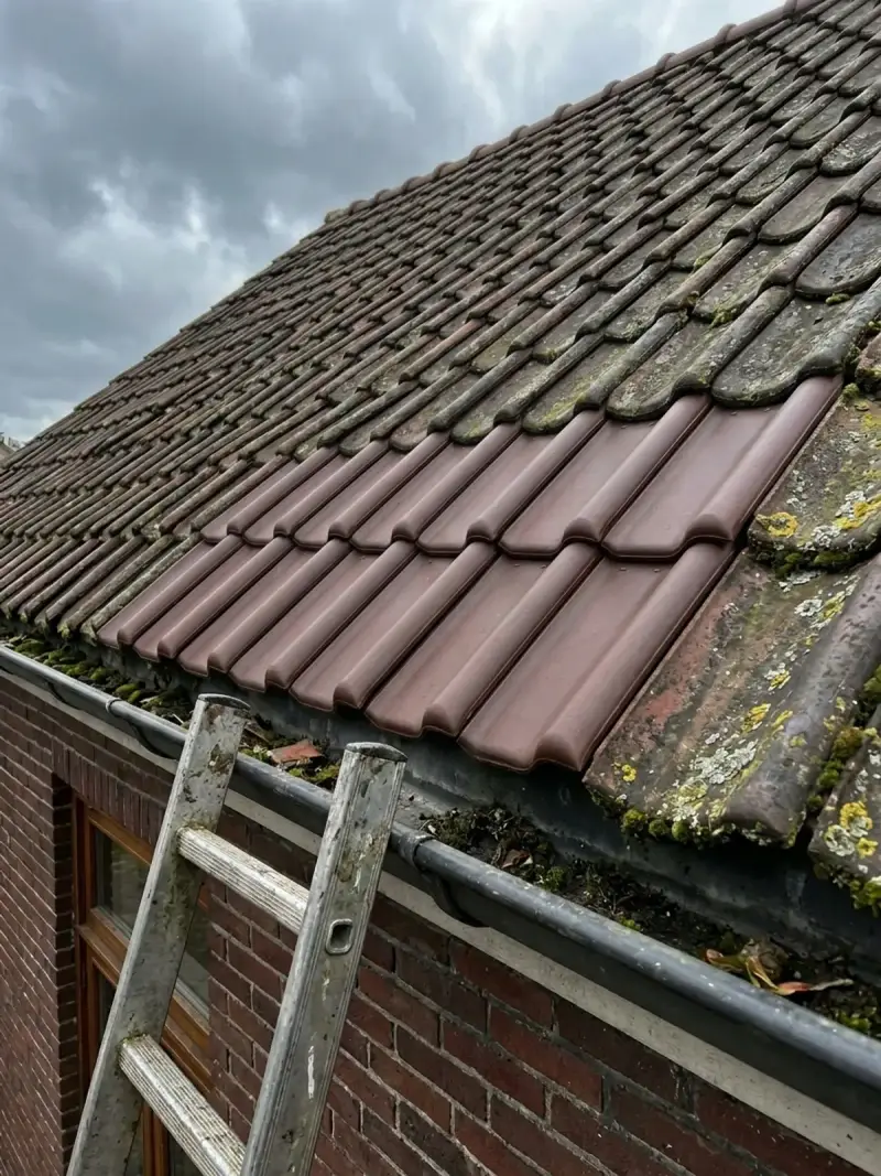 Dakdekker legt de laatste pan van de herstelde rij op zijn plek